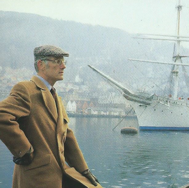 Per Grieg posing well dressed in front of a sailboat in Bergen.
